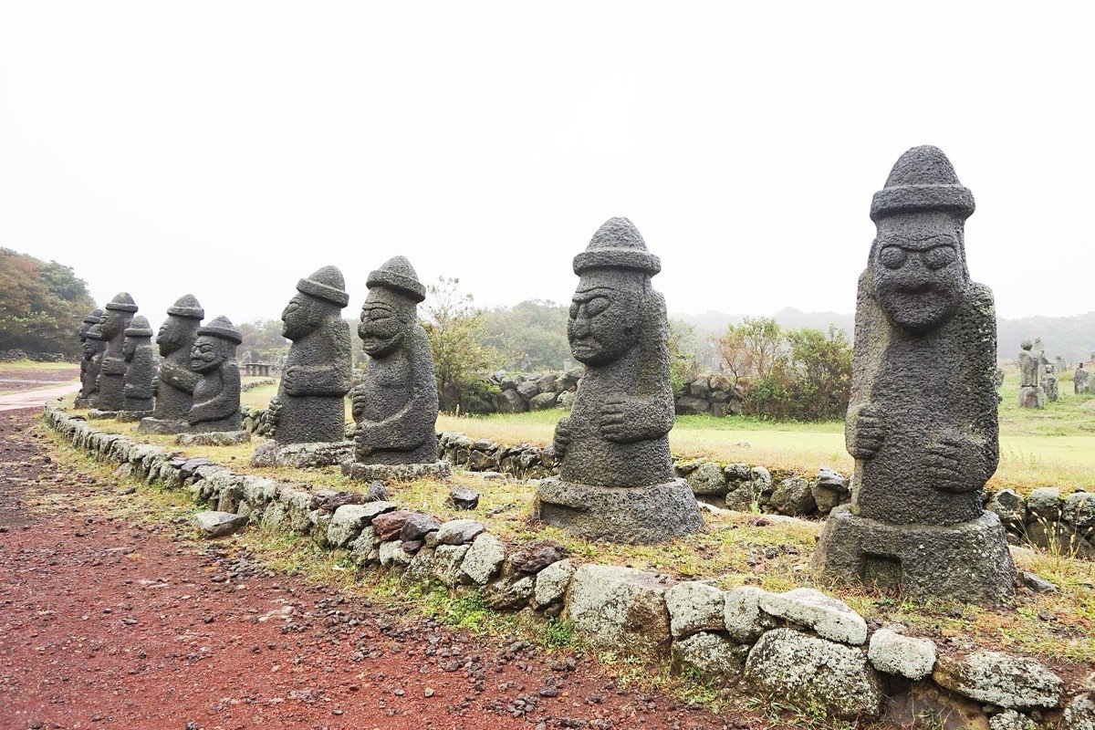 A dol hareubang stone statue with a round hat and bulging eyes