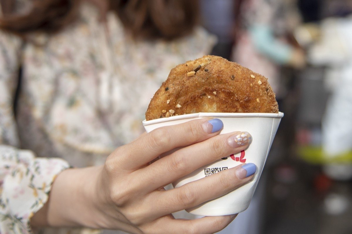 Seed hotteok held in a paper cup